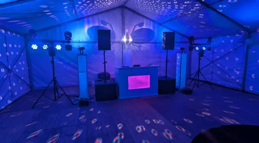 Professionele drive-in show van DJ CrazyVibes met blauwe verlichting en discobal tijdens een feest in een tent in Bingelrade, regio Geleen