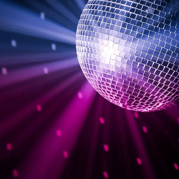Grote glazen spiegelbol met sfeervolle paarse en blauwe lichtstralen voor een discofeest in Limburg.