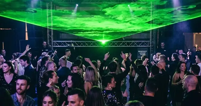 Exclusief groen Liquid Sky lasereffect boven een volle dansvloer van Nightshift Entertainment.